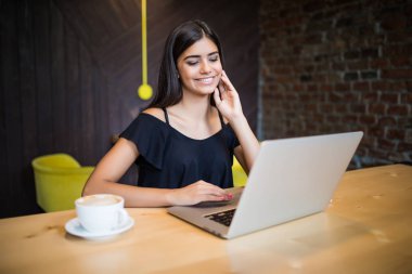 Güzel esmer kafede dizüstü kullanarak