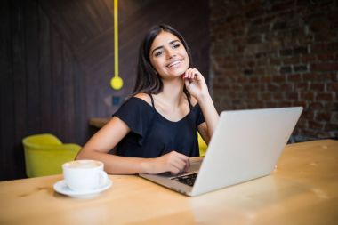 Güzel esmer kafede dizüstü kullanarak