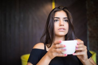 Kahve içme bir kafede oturan genç güzel kadın portresi