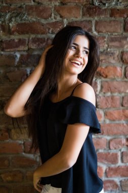 Genç güzel mutlu kadını duvara karşı rahat kıyafetler