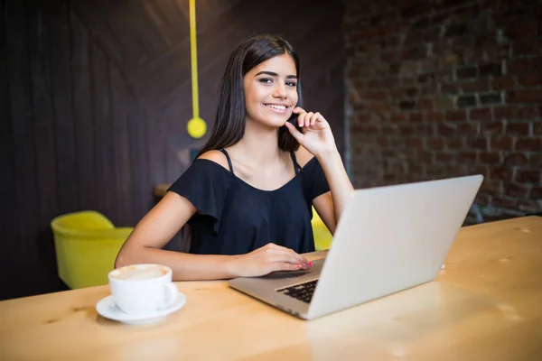 Beautiful attractive woman at the cafe with a laptop having a coffee break — Stock Photo, Image