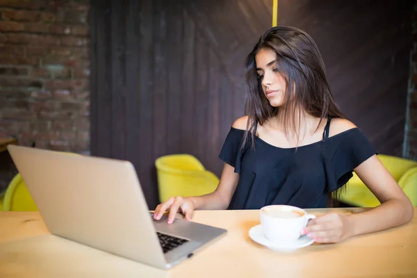 Hermosa morena usando portátil en la cafetería — Foto de Stock