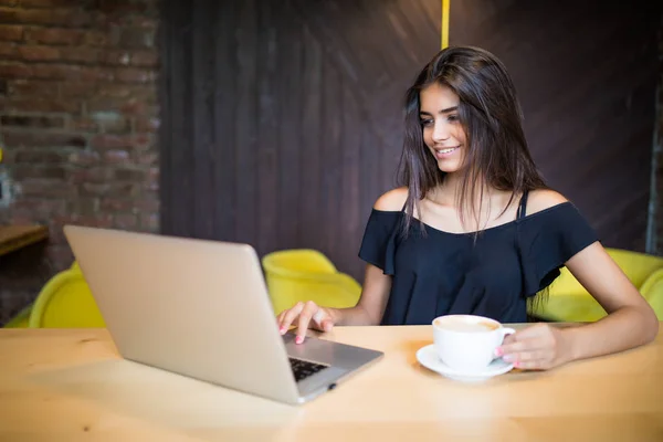 Beautiful brunette using laptop in cafe — Stock Photo, Image