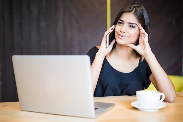 Portrait of pretty woman talking with bad emotions on the phone while sitting in the cafe and enjoying coffee — Stock Photo, Image