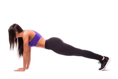 Güzel fitness kız eşofman bir tahta üzerinde beyaz arka plan yaparken egzersiz yoğunlaştı