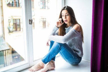 Hoş sohbet tadını çıkarıyor. Pencere pervazına üzerinde otururken Evet çekici genç kadın