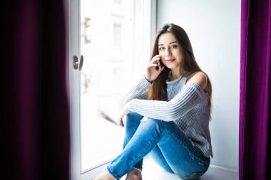 Hoş sohbet tadını çıkarıyor. Pencere pervazına üzerinde otururken Evet çekici genç kadın