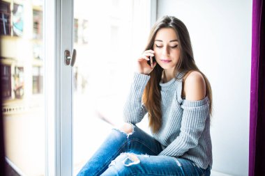 Hoş sohbet tadını çıkarıyor. Pencere pervazına üzerinde otururken Evet çekici genç kadın