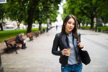genç güzel esmer kahve şehirde yürüyüş içme.