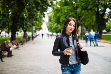 sabah kahve ile sokakta yürürken gülümseyen güzel kız