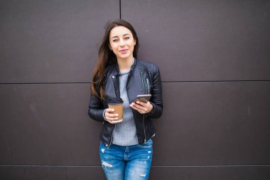 Akıllı telefon kullanan çekici genç kadın. Kahve molası