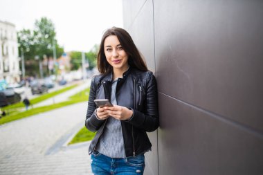 Akıllı telefon kullanan çekici genç kadın. Kahve molası