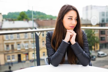 Yalnız sipariş için Teras bekleme kafede oturan güzel ve genç birbayan. Alışveriş sonra kahve molası. kafede kahve güzel genç kadın