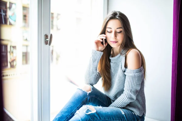 Hoş sohbet tadını çıkarıyor. Pencere pervazına üzerinde otururken Evet çekici genç kadın