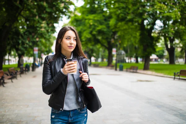 Sonriente chica bonita caminando en la calle con café de la mañana —  Fotos de Stock