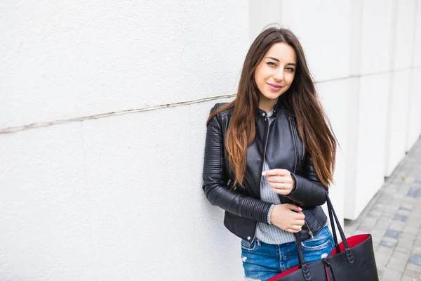 Mujer joven y elegante con bolso de mano caminando por la calle de la ciudad — Foto de Stock