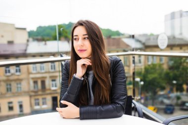 Yalnız sipariş için Teras bekleme kafede oturan güzel ve genç birbayan. Alışveriş sonra kahve molası. kafede kahve güzel genç kadın