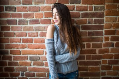 Ciddi esmer kadına karşı kırmızı tuğla duvar closeup fotoğraf