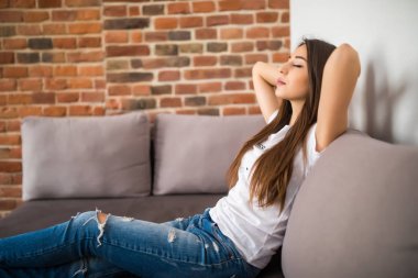 gülümseyen genç kadın elinde kanepe üzerinde kafa yalan gözler kapalı