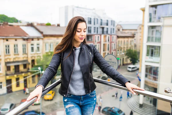 Niña de pie en la terraza, vista del panorama de la ciudad, vista de la distancia . — Foto de Stock