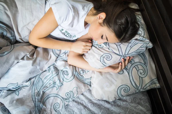Gros plan portrait d'une jeune jolie femme calme qui dort et étreint son oreiller au lit — Photo