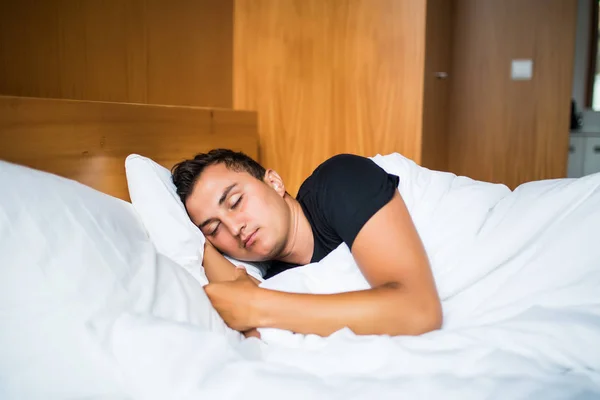 Bel homme confortablement dormir dans son lit la nuit — Photo
