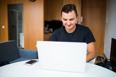 Çalışma from home dizüstü bilgisayarda sabah masada oturan adam
