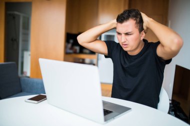 Evden dizüstü bilgisayarda çalışan mutsuz kendi hesabina işadamı