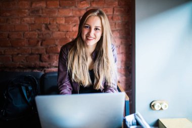 Cafe masada oturan dizüstü bilgisayar kullanan güzel genç Freelancer kadın. Çevrimiçi çalışıyorsanız veya eğitim ve dizüstü bilgisayar kullanırken öğrenme mutlu gülümseyen kız.