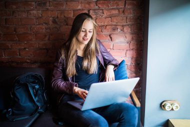 Cafe masada oturan dizüstü bilgisayar kullanan güzel genç Freelancer kadın. Çevrimiçi çalışıyorsanız veya eğitim ve dizüstü bilgisayar kullanırken öğrenme mutlu gülümseyen kız.