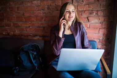 Restoranda oturan genç kadın konuşan iken ve kahve keyfini çıkarın