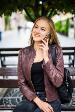 genç kadın veya genç kız smartphone üzerinde şehir sokak arama gülümseyen