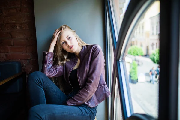 Pencere pervazına kafede oturan genç kadın