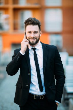 Genç yakışıklı işadamı şehir sokak açık havada onun cep telefonu konuşurken sakallı