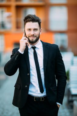 Genç yakışıklı işadamı şehir sokak açık havada onun cep telefonu konuşurken sakallı