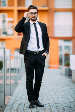 Klasik takım elbiseli yakışıklı sakallı işadamı uzak ofis Merkezi balkonunda dururken arıyor