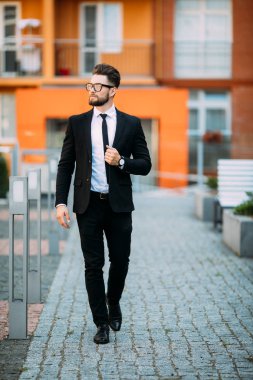 Klasik takım elbiseli yakışıklı sakallı işadamı uzak ofis Merkezi balkonunda dururken arıyor