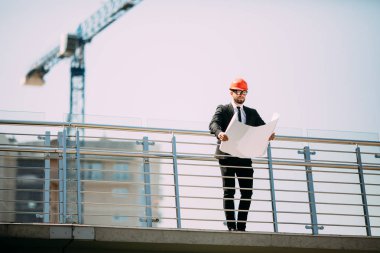 Şantiye planı elinde tutan insanlar mühendislik danışmanlık yakışıklı adam. Bina müfettişi. Çizim inşaat site denetimi ve yeni binanın iş iş akışı