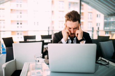 Yakışıklı iş laptop ile baş ağrısı, Teras kafe dükkanda woking dostum.