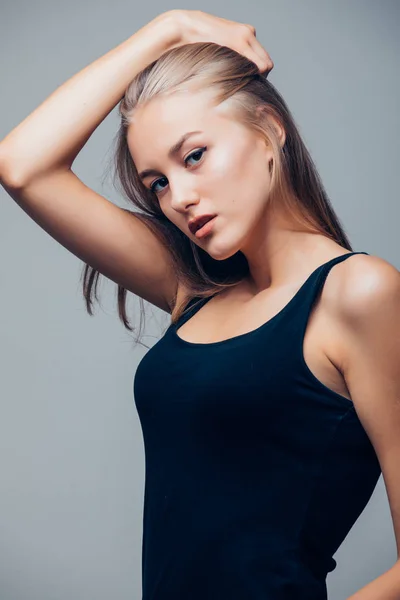 Gyönyörű fiatal nő, a fekete ing a szürke háttér — Stock Fotó