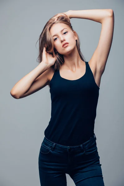 Gyönyörű fiatal nő, a fekete ing a szürke háttér — Stock Fotó