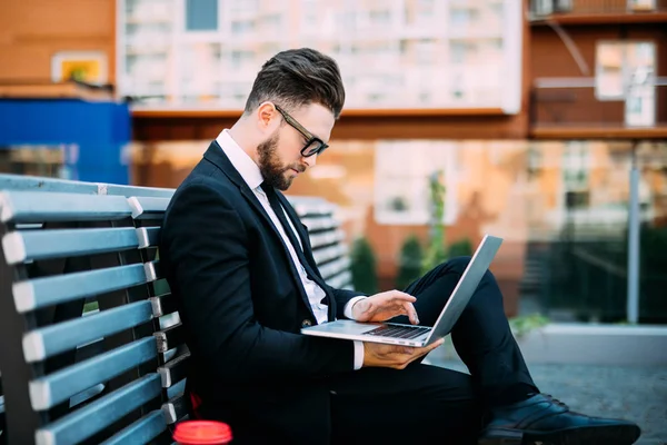 Tezgah oturma ve laptop ve içki sabah kahve üzerinde çalışan genç işadamı