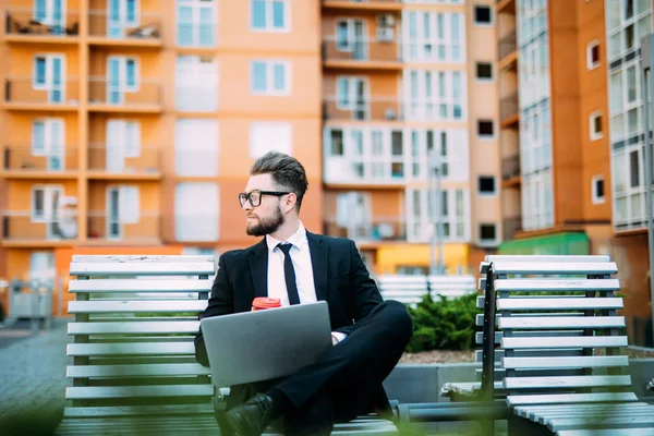 Tezgah oturma ve laptop ve içki sabah kahve üzerinde çalışan genç işadamı