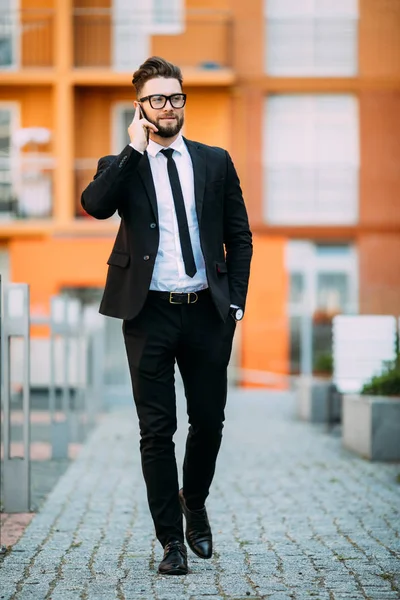Klasik takım elbiseli yakışıklı sakallı işadamı ofis Balkonda duran bir akıllı telefon kullanıyor — Stok fotoğraf