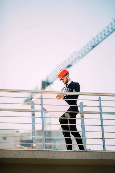 Stilig man Engineering Consulting personer på byggarbetsplats håller blueprint i handen. Byggnad inspektör. Konstruktion webbplats kontrolleras ritning och business arbetsflöde i nya byggnaden — Stockfoto