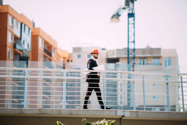 Başarı mühendis beyaz kask Emanet ve mavi baskı planları bina denetlemek için.