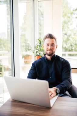 Ofisinde laptop ile iş yerinde yakışıklı işadamı