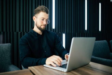 Şık modern ofis içinde işadamı çalışma laptop sakallı. Adam iş Office başlangıç projesi.