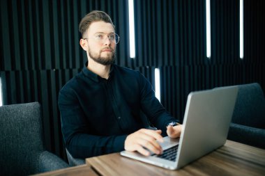 Yakışıklı işadamı modern ofis içinde laptop ile çalışma