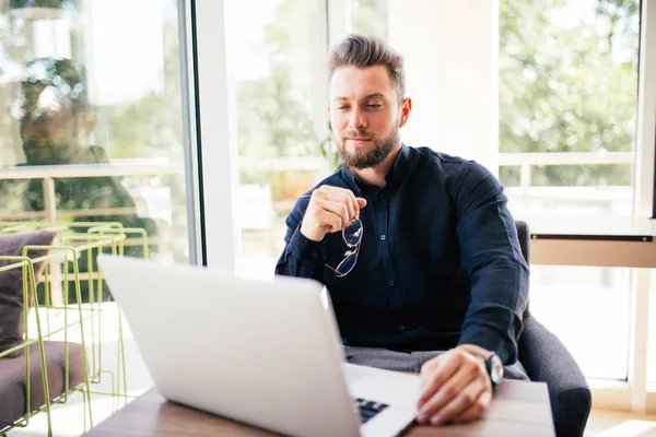 Elinde ofiste onun masasında oturan gözlüklü genç adam portresi